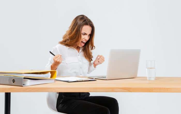 Kobieta się złości w wyniku nie włączenia laptopa
